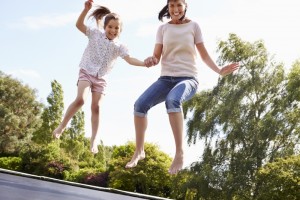 12121808-mother-and-daughter-bouncing-on-trampoline-together